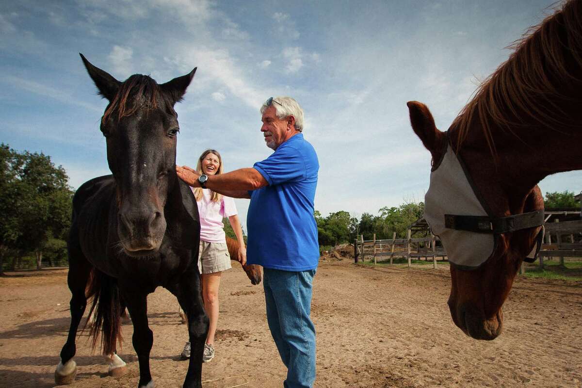 Jerry Finch, right, President and Founder of Habitat for Horses, and Rebecca Williams, Executive Director, share a laugh with Merlin, at the Habitat for Horses ranch.