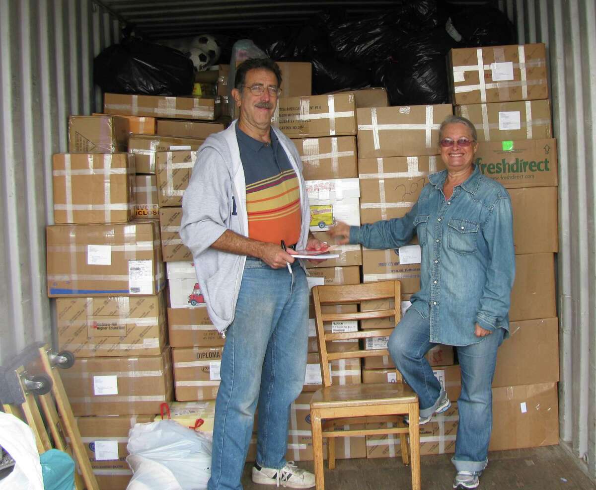 Mark Grashow, president of U.S.- Africa Children's Fellowship, left, stands with Relly Coleman, founder and president of Books for Zim, in front of over 1,600 pounds of books to be shipped to Zimbabwe.