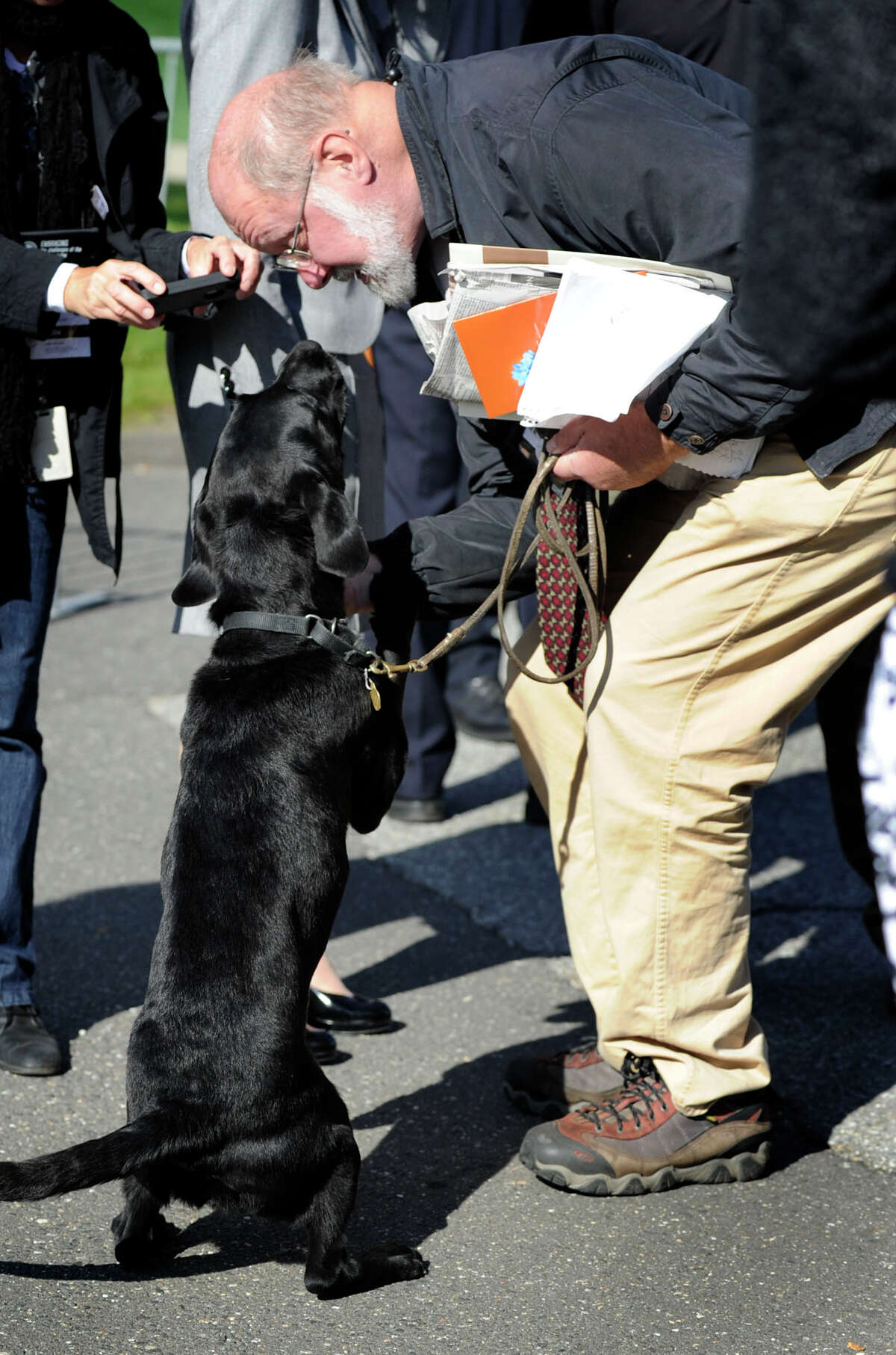 News-Times reporter Bob Miller, makes friends with a contraband-sniffing dog before a sweep of media and their equipment. A large turn out of media turned up at Western Connecticut State University to cover a visit by the Dalai Lama Thursday, Oct. 18, 2012.