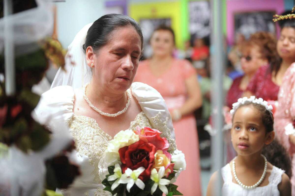 Bride Velia Estrada listens during her wedding ceremony at the San Antonio Lighthouse for the Blind on Friday, Oct. 19, 2012. Estrada married Jesse Talamantes, whom she met 12 years ago at the facility. They got engaged 8 months ago. Talamantes, who has only partial peripheral vision in one eye, can often be found leading and caring for Estrada, who is completely blind. The couple is honeymooning at the Holiday Inn Riverwalk, which donated a two-night honeymoon package.