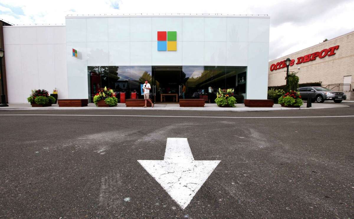 FILE - In this Thursday, Aug. 23, 2012, file photo, the new Microsoft logo is seen above the entrance to a company store in Seattle. Microsoft Corp.'s net income fell 22 percent in the latest quarter as it deferred revenue from the sale of its upcoming Windows 8 operating system to PC makers, and as PC sales in general took a dive. The software company's net income was $4.47 billion, or 53 cents per share. That was down from $5.7 billion, or 68 cents per share, a year ago, and exceeded analyst estimates, which had been in the 50-52 cent range. (AP Photo/Elaine Thompson, File)