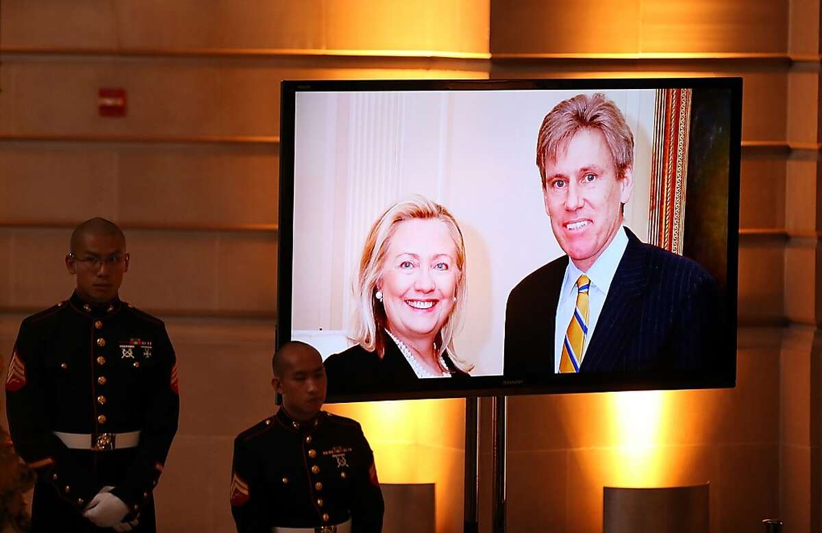 SAN FRANCISCO, CA - OCTOBER 16: U.S. Marines stand next to a television monitor that is displaying a photo of Secretary of State Hillary Clinton and former Ambassador Christopher Stevens during a memorial service for Stevens at San Francisco City Hall on October 16, 2012 in San Francisco, California. Christopher Stevens served as the U.S. Ambassador to Libya from June 2012 to September 11, 2012 when he was killed in an attack on the U.S. Consulate in Benghazi, Libya. (Photo by Justin Sullivan/Getty Images)