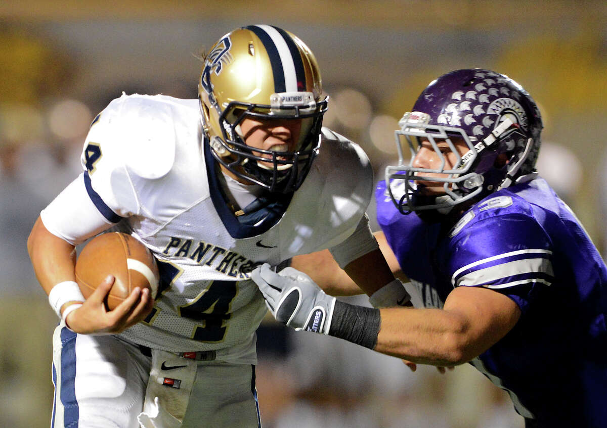 O'Connor quarterback Zach Galindo (14) tries to escape the grasp of Warren's Jerry Robertson (33) during a district football game between the Warren Warriors and the o'Connor Panthers at Farris Stadium in San Antonio, Saturday, October 19, 2012. John Albright / Special to the Express-News.