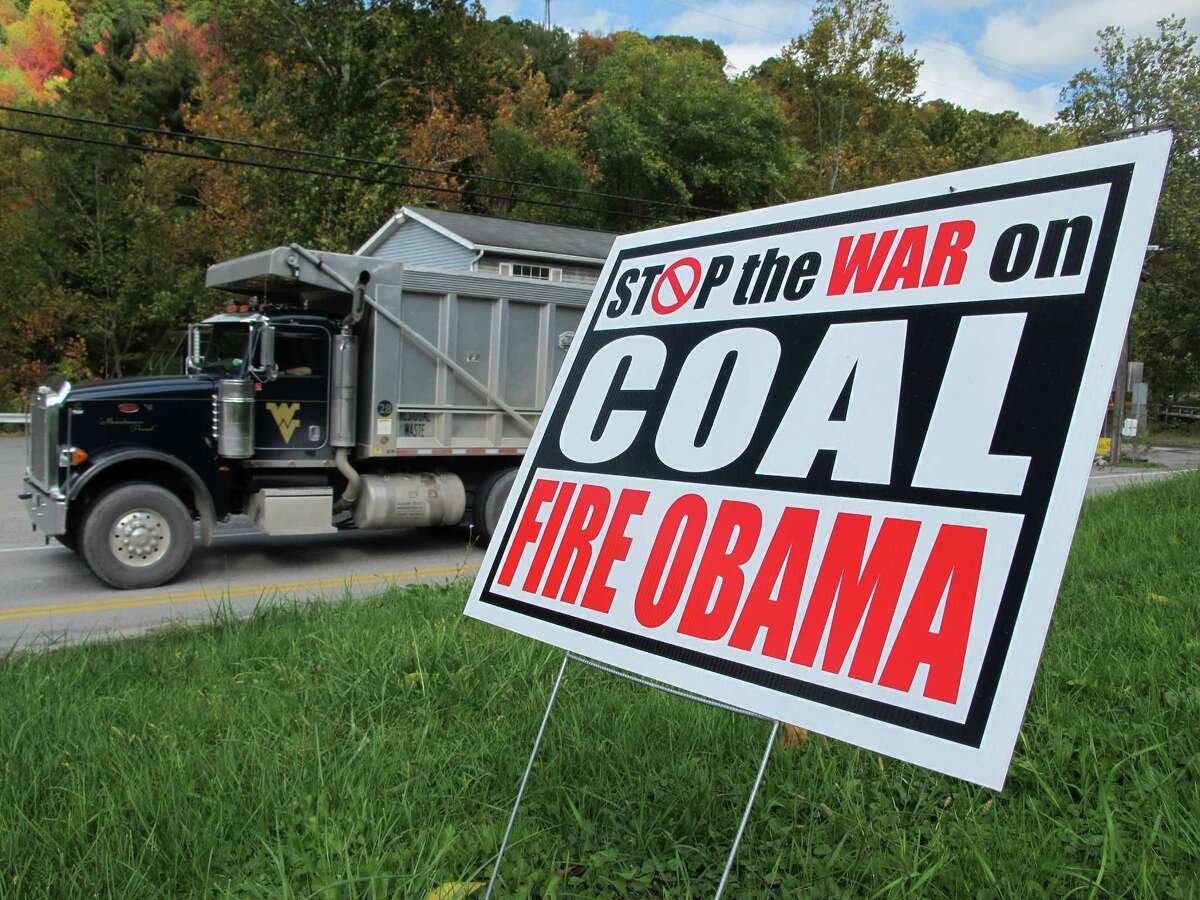 A truck passes a political sign in a yard in Dellslow, W.Va., on Oct. 16, 2012. Rhetoric about the administration's alleged "war on coal" has come to dominate conversation this campaign season. Once, coal miners were literally at war with their employers. Today, their descendants are allies in a rhetorical war playing out across eastern Kentucky, southwestern Virginia and all of West Virginia. The message: They now face a common enemy _ the federal government, especially the president and the Environmental Protection Agency. (AP Photo/Vicki Smith)