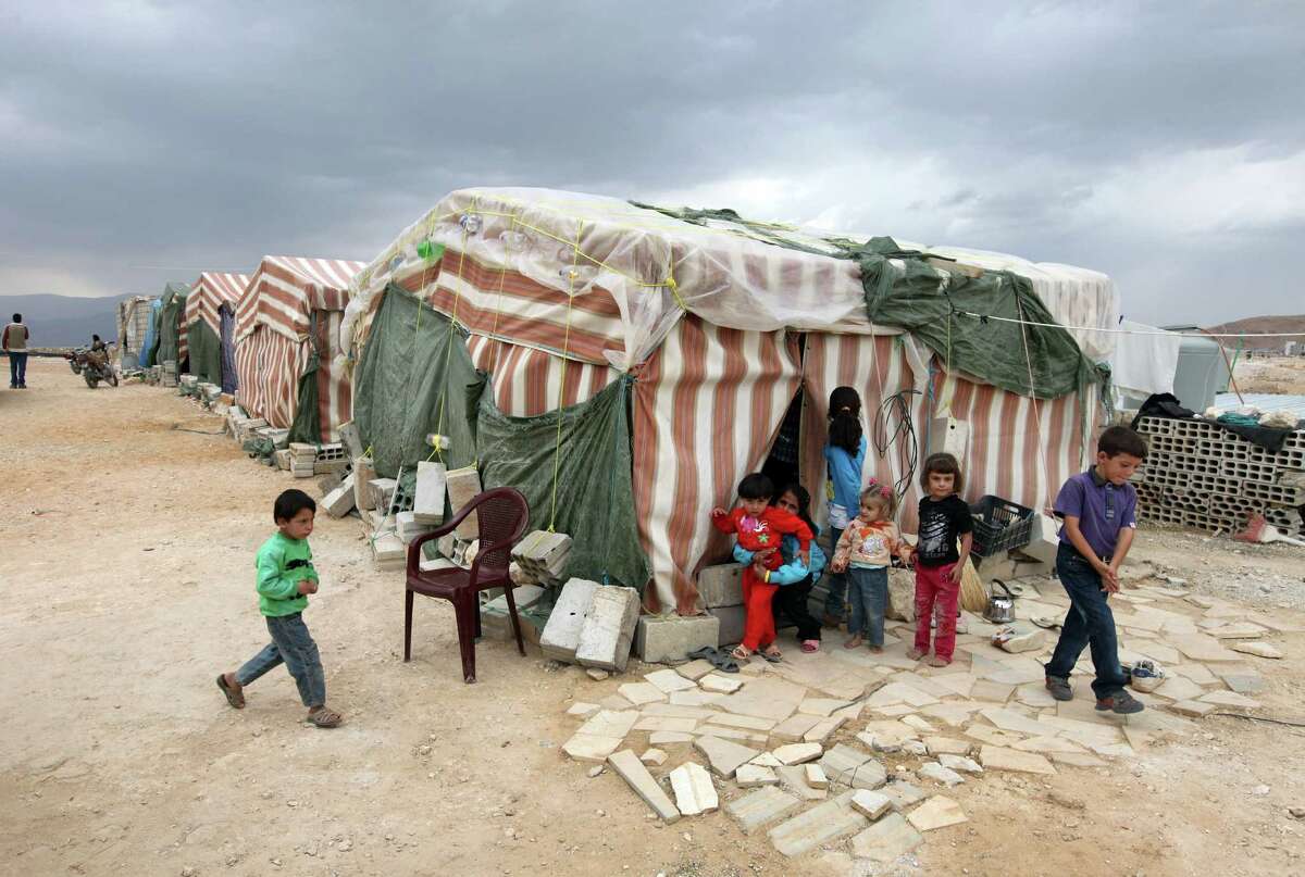 FILE - In this Tuesday, Oct. 2, 2012 photo, Syrian refugees children stand in front of their tents at a refugee camp in Arsal, a Sunni Muslim town eastern Lebanon near the Syrian border, that has become a safe haven for war-weary Syrian rebels and hundreds of refugee families. Syria has a long and tumultuous history of meddling into Lebanese affairs. For much of the past 30 years, the seven-times-smaller Lebanon has lived under Syrian military and political domination. Since the uprising against President Bashar Assad began in February 2011, Lebanon has been steadily drawn into the unrest ? a troubling sign for the country with political parties rooted in various Christian and Muslim sects, many of which are armed. (AP Photo/Bilal Hussein, file)