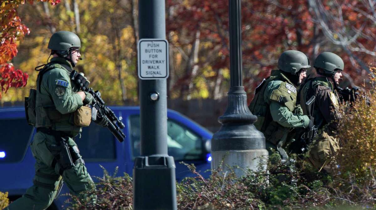 Police and swat team members respond to a call of a shooting at the Azana Spa in Brookfield, Wis. Sunday , Oct. 21, 2012. Multiple people were wounded when someone opened fire at the spa near the Brookfield Square Mall. Deputies are still looking for the gunman. (AP Photo/Tom Lynn)