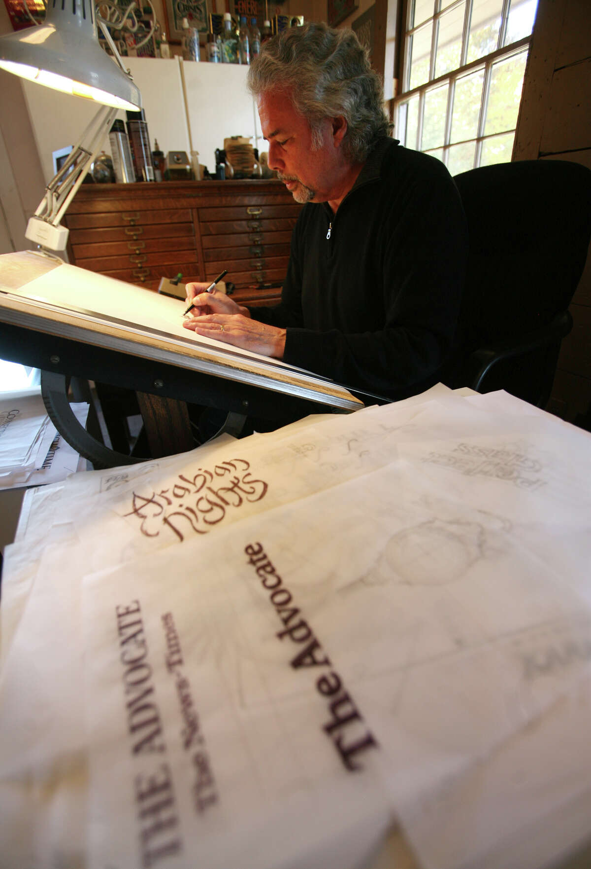 Gerard Huerta, creator of the new masthead designs for Hearst Connecticut Newspapers, works in his studio in the Southport section of Fairfield.
