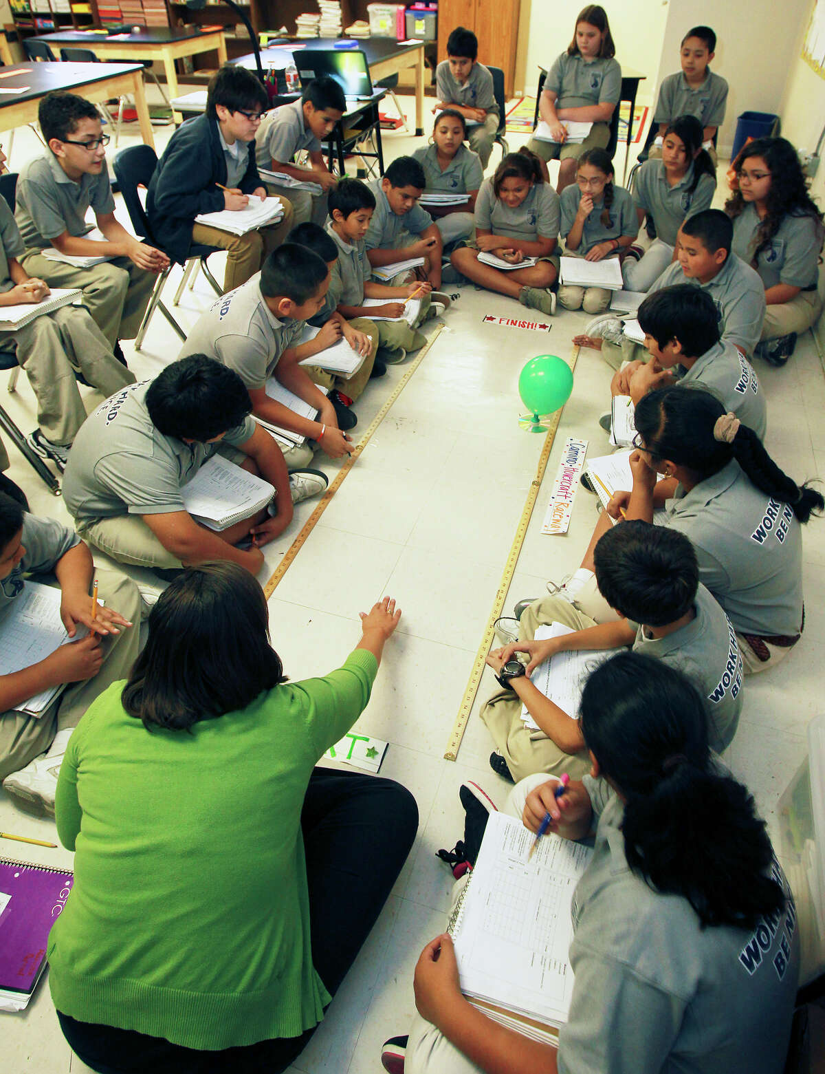 Students in Jennifer Ortegon's fifth grade science class time the release of air from a baloon experiment as KIPP Camino Academy conducts classes on October 17, 2012.