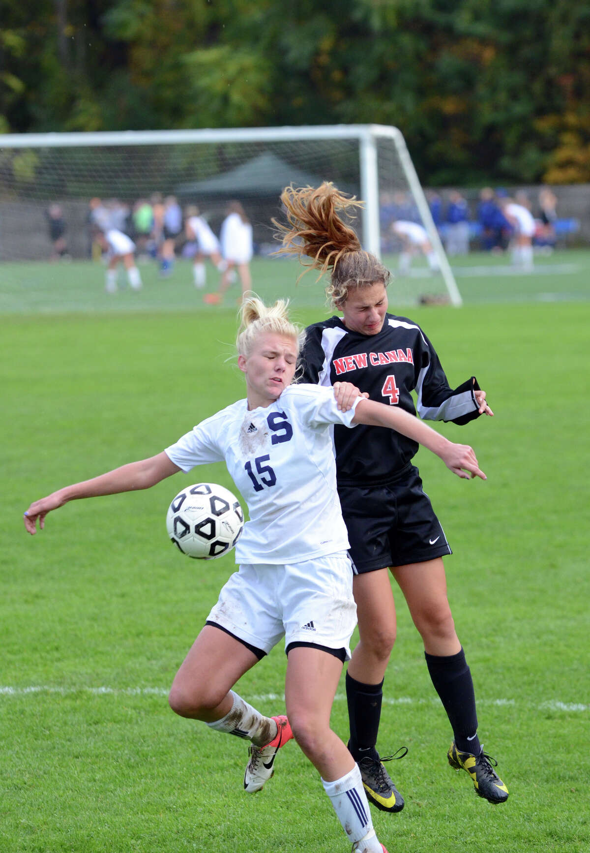 New Canaan's Marina Braccio (4) challenges Staples' Ryan Kirshner (15) for the ball during the girls soccer game at Loeffler Field at Staples High School in Westport on Tuesday, Oct. 23, 2012.