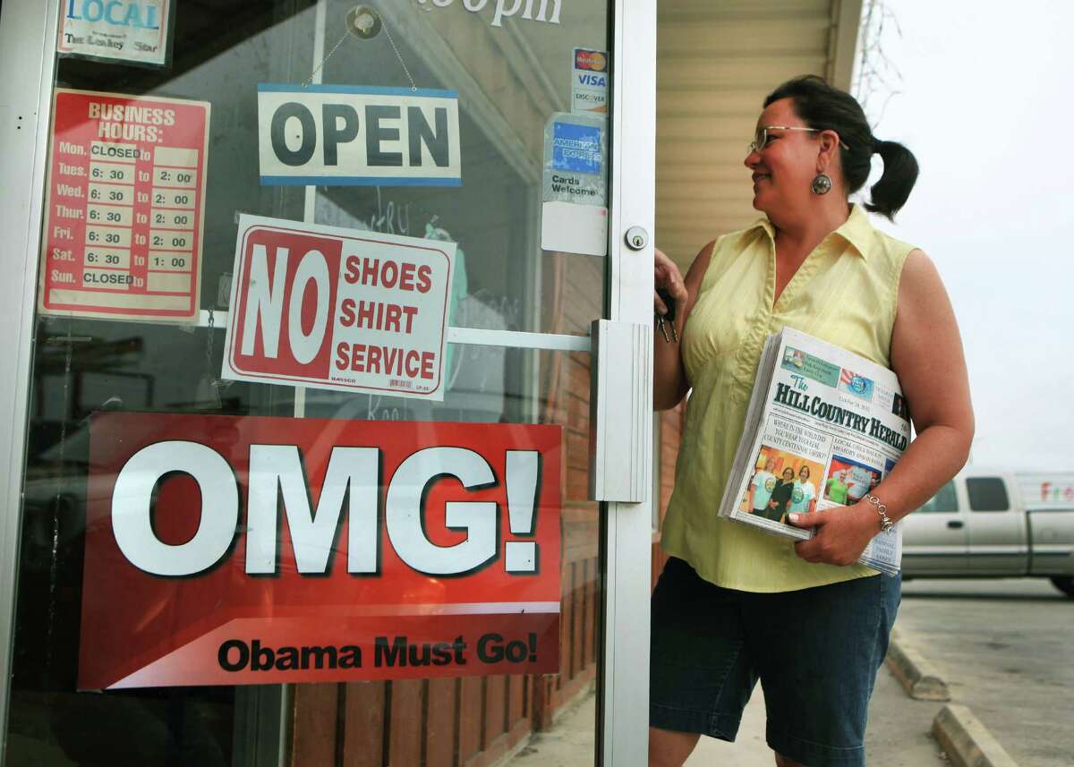 Julie Becker, Editor and Publisher of The Hill Country Herald in Leakey, TX, drops off a stack of the latest edition at Hill Country Bar-B-Que Restaurant. The restaurant, owned by Shawna Romo, proudly posted the sign "Obama Must Go", on the front door. Most people in the town of Leakey think nothing of the sign Pastor Ray Miller put on his church, Church in the Valley, two weeks ago which read "Vote for the Mormon, Not the Muslim". Becker said she wouldn't report on anything Miller says. Wednesday, Oct. 24, 2012.