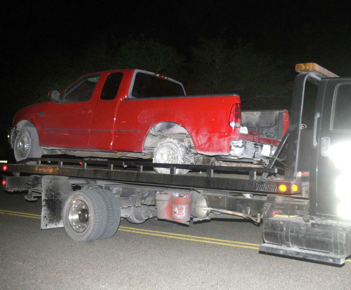A red pickup truck is moved from the scene after a chase between law enforcement and suspected human smugglers on 7 mile road north of La Joya, Thursday, Oct. 25, 2012. Texas Department of Public Safety sharpshooter opened fire on an evading vehicle loaded with suspected illegal immigrants, leaving at least two people dead, sources familiar with the investigation said.