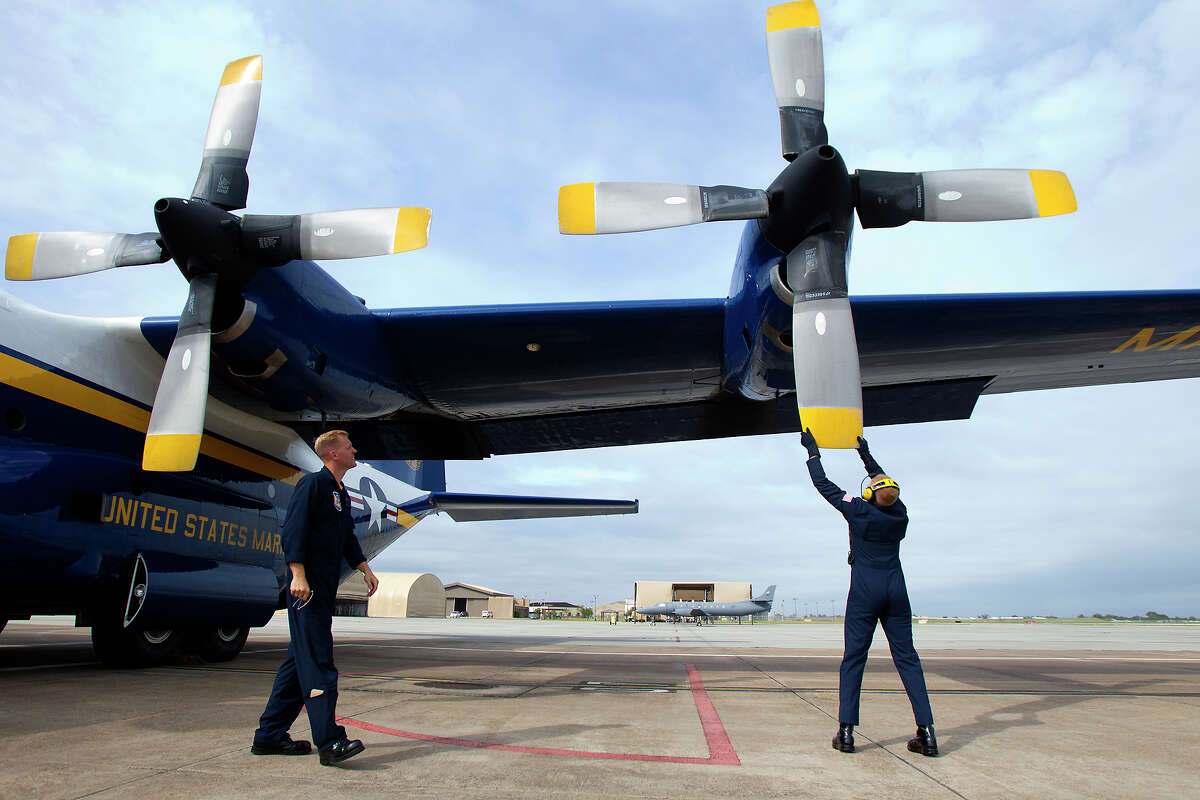Marine Blue Angels Gunnery Seargeant Micah Bachtold, left watches as Staff Seargeant Adam Miller stops a prop after a flight aboard the Blue Angel's Fat Albert C130 airplane at Ellington Field Friday, Oct. 26, 2012, in Houston.