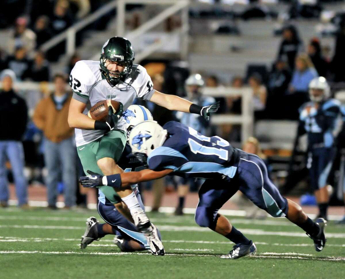 Reagan receiver John Grubb is tackled by Johnson's Fernando Cruz (15) after making a midfield catch.
