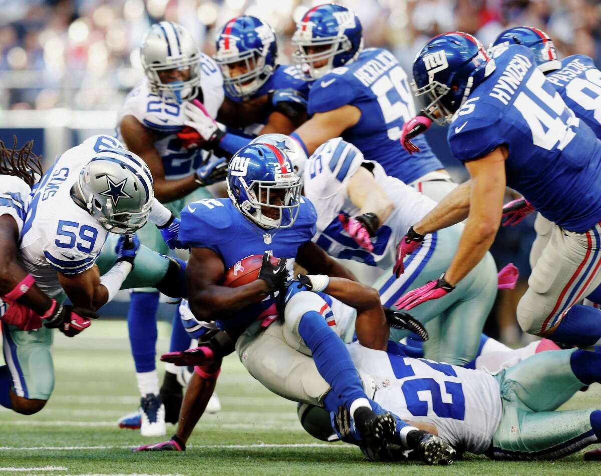 New York Giants running back David Wilson (22) is taken down by a host of players including Dallas Cowboys strong safety Eric Frampton (27) during the first half of an NFL football game Sunday, Oct. 28, 2012 in Arlington, Texas. (AP Photo/Sharon Ellman)