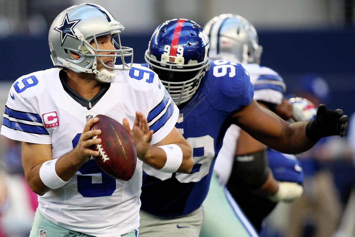 Dallas Cowboys' quarterback Tony Romo gets pressure from New York Giants' Chris Canty during the first half at Cowboys Stadium in Arlington, Texas, Sunday, Oct. 28, 2012.