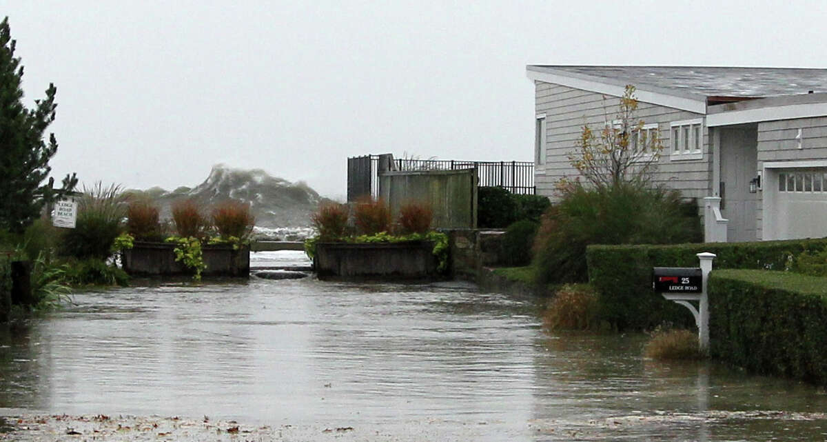 A large wave breaks over onto Ledge Road in Old Greenwich, Conn. on Monday, Oct. 29, 2012.