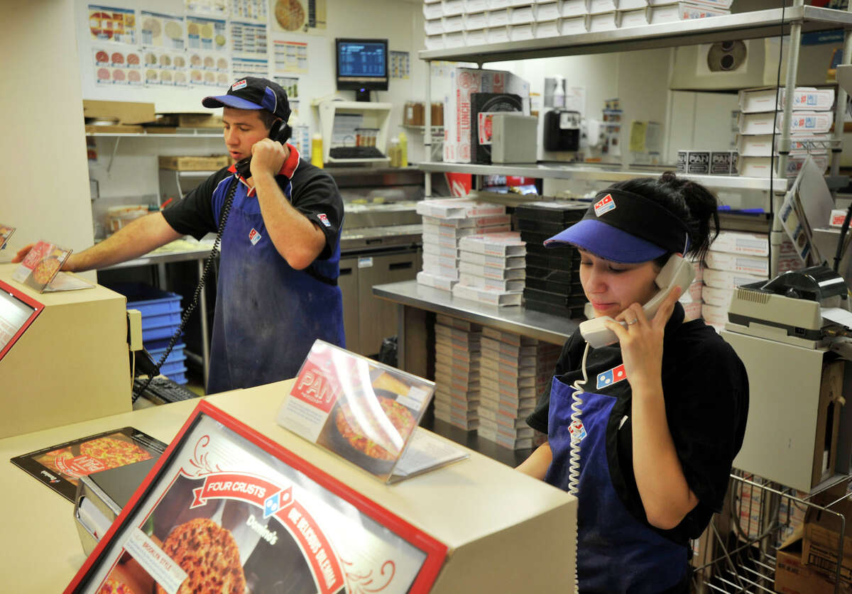 Manager John DaSilva, left, and Nicole Vitiello, a customer service representative, take orders over the phone at Domino's on Tamarack Avenue in Danbury during former Hurricane Sandy on Monday, Oct. 29, 2012. Domino's was taking delivery orders into the evening Monday.