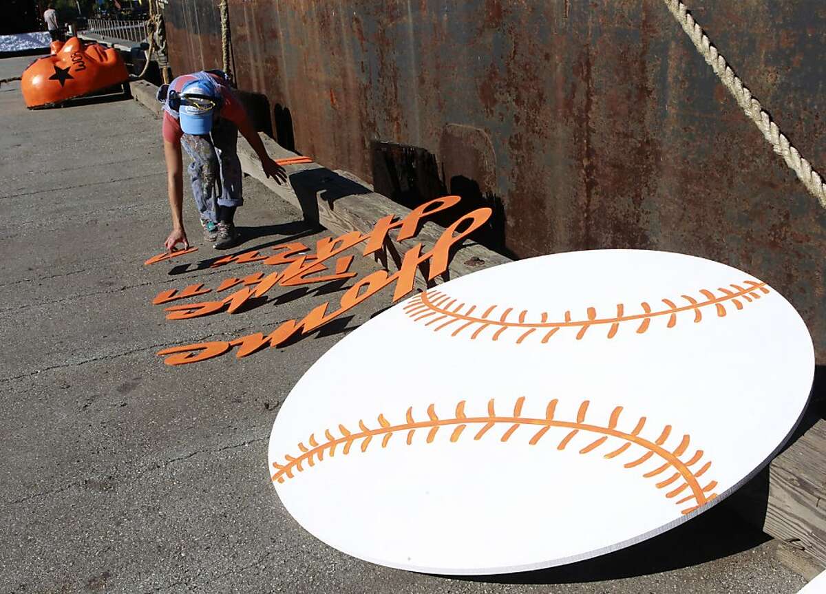 Allison Lowe lays out letters spelling "Home Run" before adding it to a float for the Giants World Series victory parade in San Francisco, Calif. on Tuesday, Oct. 30, 2012.