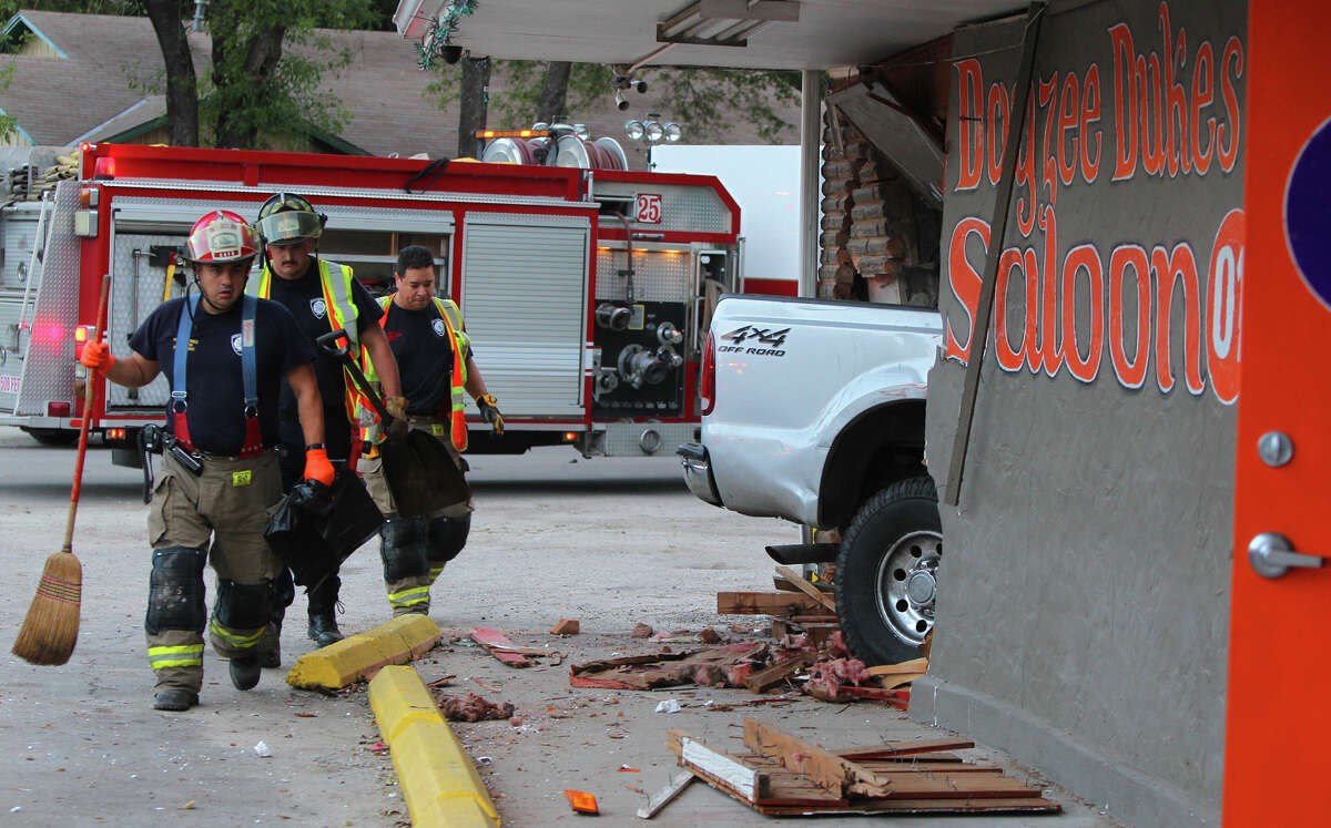 San Antonio firefighters investigate the scene Wednesday morning October 31, 2012 at 1806 Quintana road where an F-250 Ford pickup crashed into the Dayzee Dukes Saloon at about 7:00 a.m. . Police said the truck was southbound on Quintana when it veered into oncoming traffic and clipped a Hyundai Accent and crashed directly into the bar. Witnesses and police said a woman wearing high heel shoes was seen fleeing the scene. Nobody was injured during the incident.