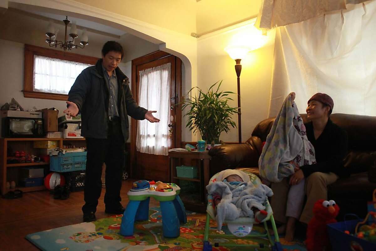 Mark Gin (left) talks with his wife, Jenny Gin (right) in their living room with their daughters Emily Gin, 8 months, (second from left) and Angela Gin, 3, (second from right) in San Francisco on Tuesday, October 30, 2012.
