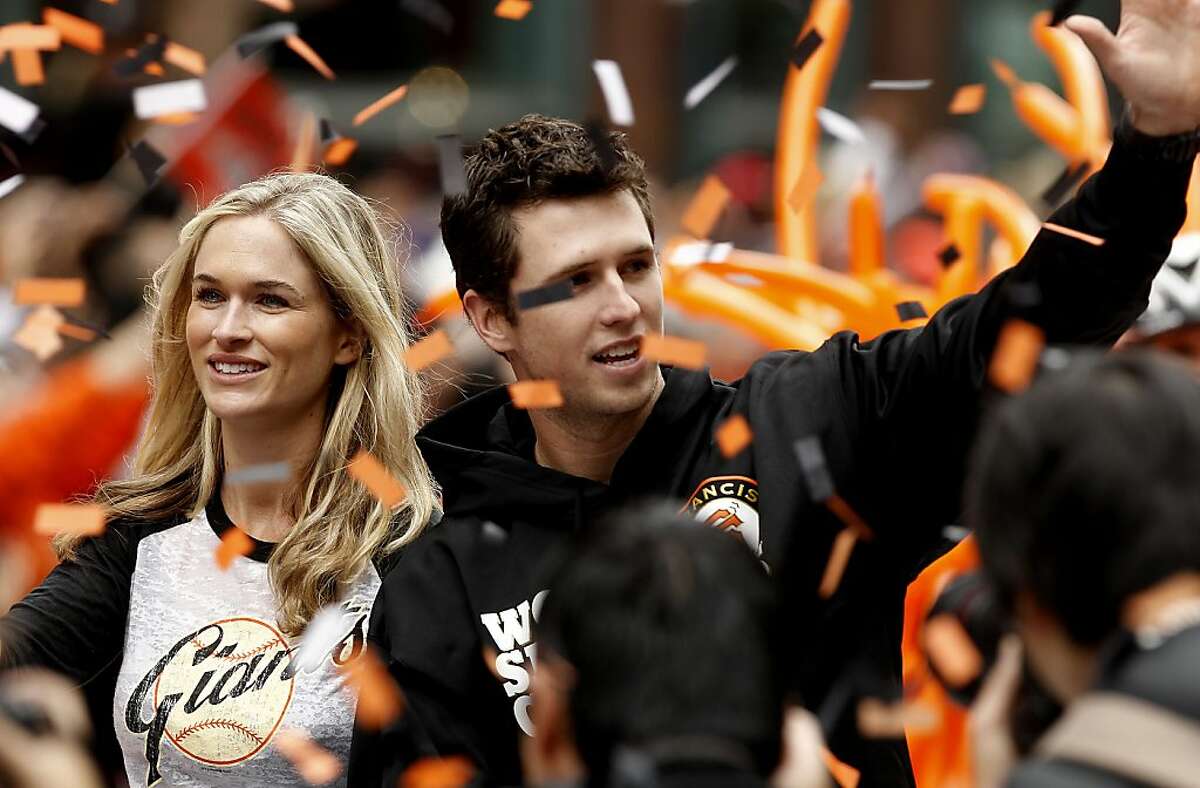 San Francisco Giants' Buster Posey and his wife Kristen wave to fans as the San Francisco Giants celebrate their World Series Championship with a parade up Market Street in downtown San Francisco, Calif., on Wednesday Oct. 31, 2012.