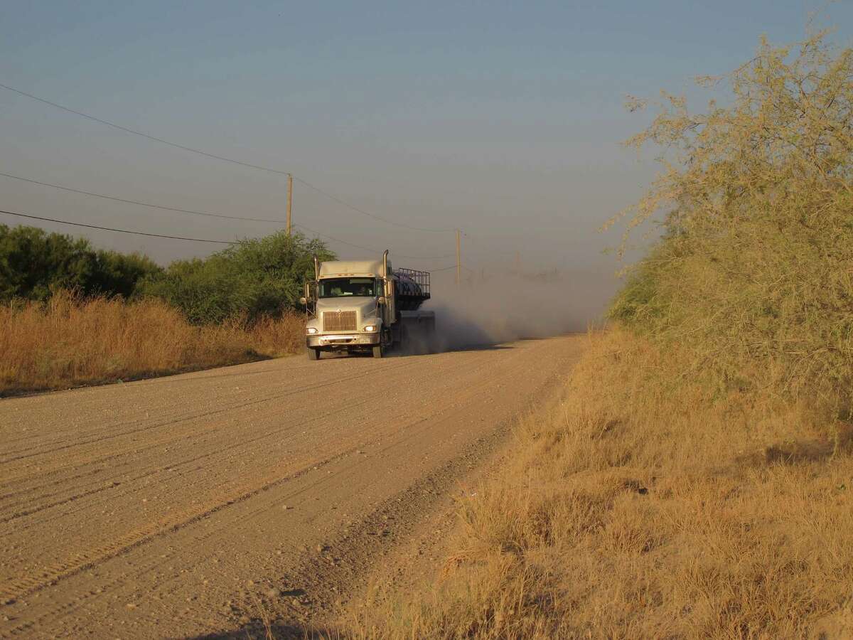 A truck travels along the stretch of gravel road near La Joya, Texas, Friday Oct. 26, 2012, where a Texas Department of Public Safety helicopter and sharpshooter assisted the previous day in the chase of a suspected illegal immigrant smuggler. Two people in the fleeing vehicle were killed and a third was wounded.