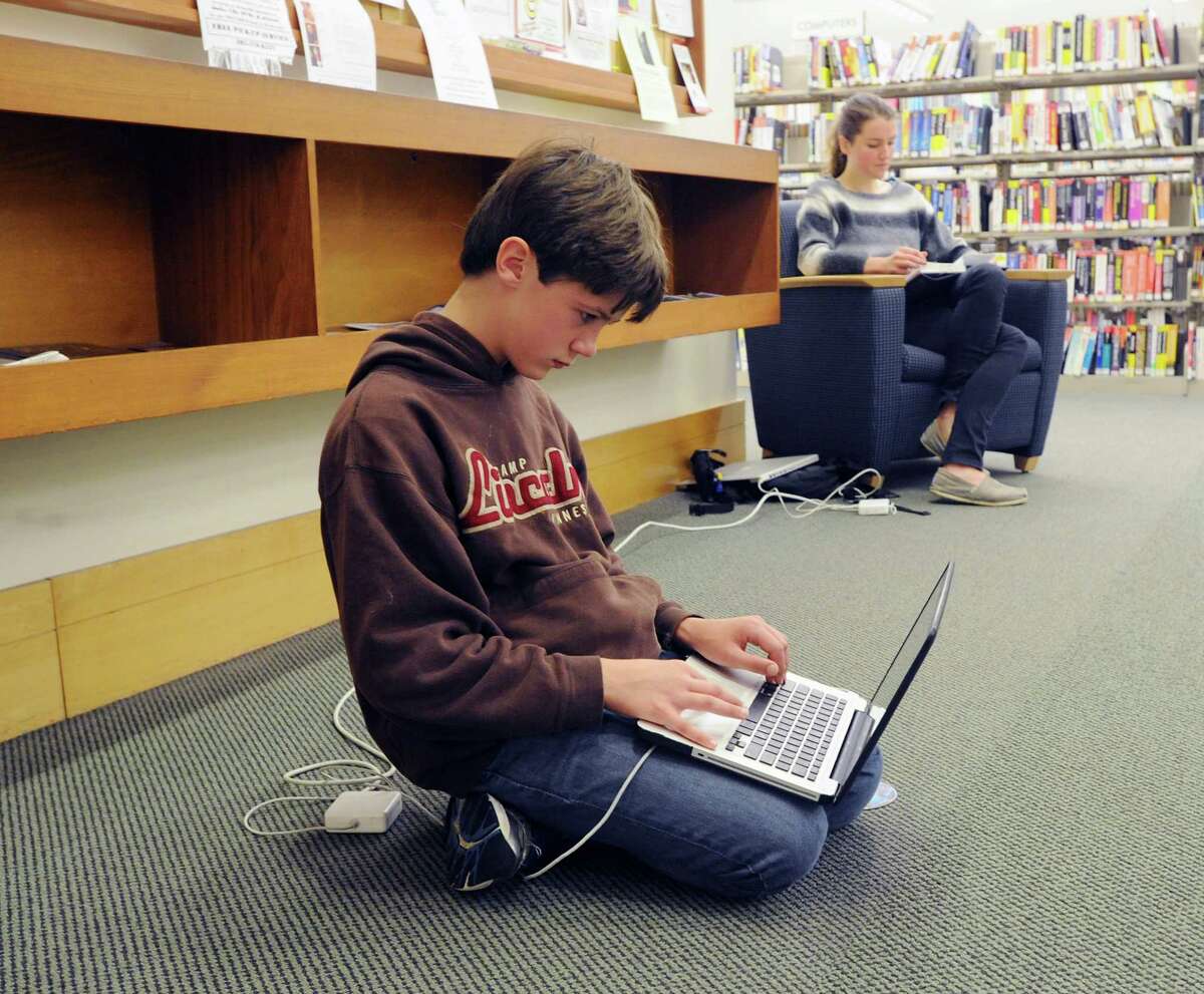 Wiliam Dunn, 12, of Greenwich, plugged in and using the internet at Greenwich Library, Wednesday morning, Oct. 31, 2012. Dunn and much of Greenwich are still without electricity due to Hurricane Sandy making the library and its amenities have become a gathering spot for the community.