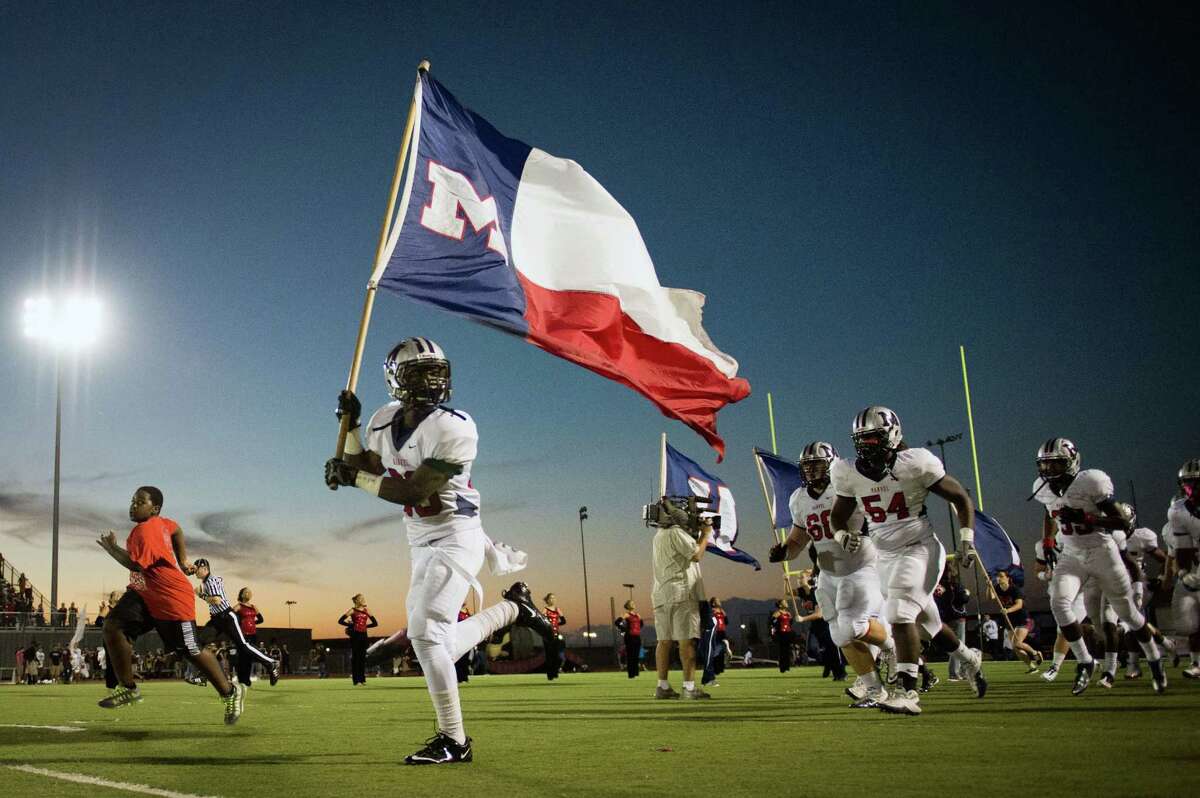 Manvel defensive back Gary Haynes carries the flag as he leads the Mavericks onto the field before their 42-28 win over Pearland.