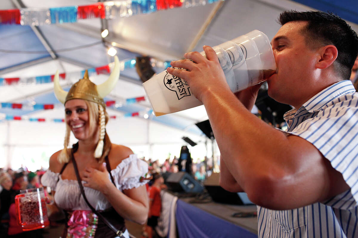 Cheyenne Hodges, left, and Michael Tashnick, both of Austin, drink and dance by the stage as the Alex Meixner Band plays during Wurstfest in New Braunfels on Saturday, Nov. 3, 2012.
