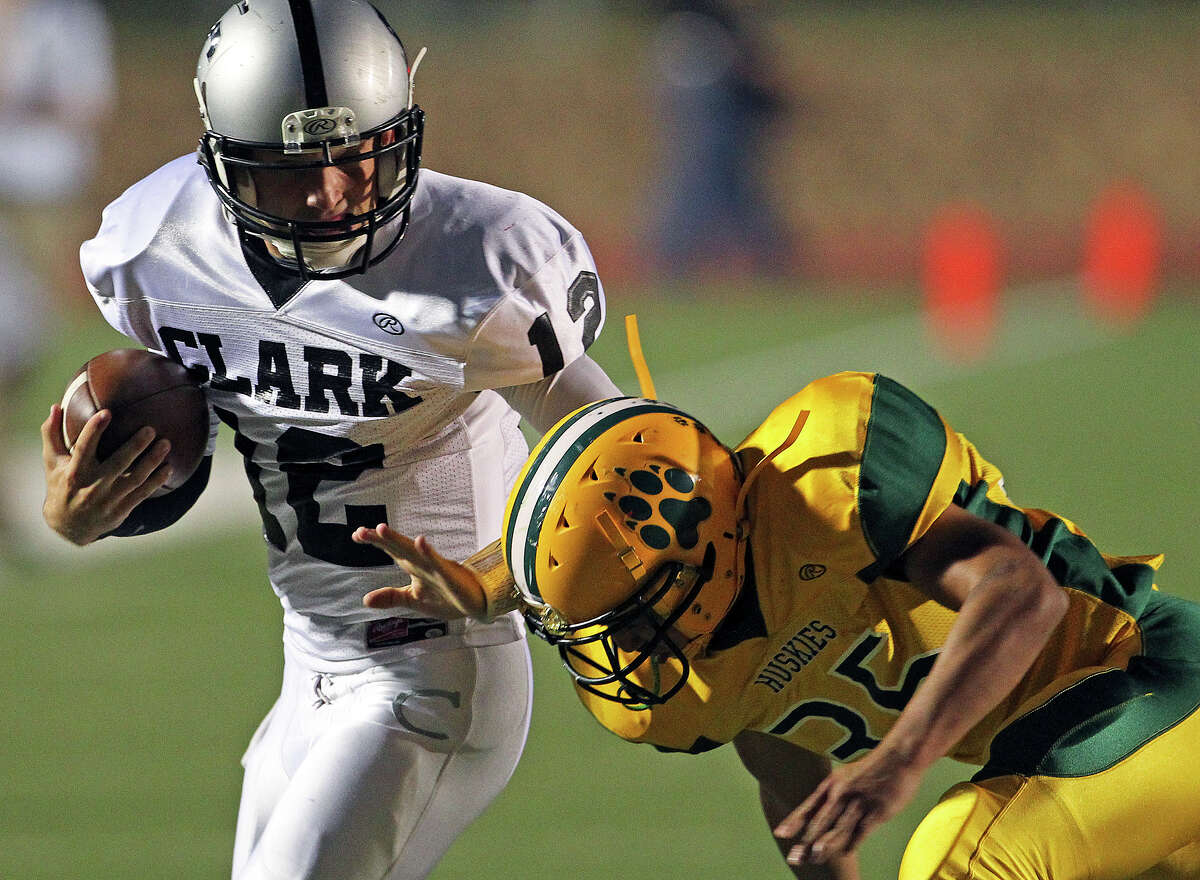 Cougar quarterback Chase Jones slides away from Rene Ortiz as Holmes plays Clark at Gustafson Stadium on November 3, 2012.
