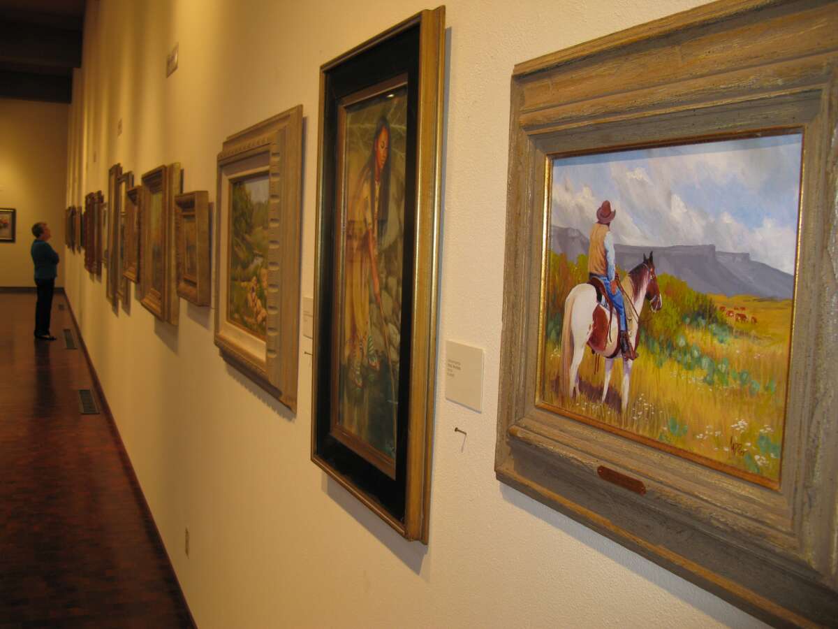 Marilyn Andrus, a volunteer at The Museum of Western Art in Kerrville, enjoys works in one of four galleries at the facility that is preparing to celebrate its 30th year in existance. Zeke MacCormack/Express-News