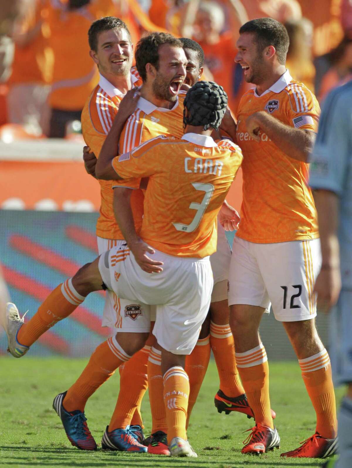 Houston Dynamo Adam Moffat, left center, celebrates his goal with teammate (3) Calen Carr and Will bruin, right, and others during first half against the the Sporting Kansas City in the MLS Eastern Conference semifinal at the BBVA Compass Stadium Sunday, Nov. 4, 2012, in Houston.