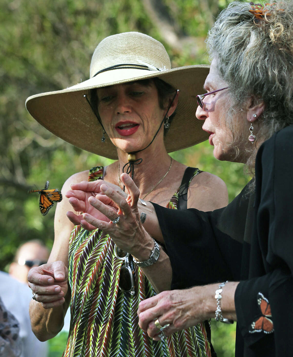 Maraleen Manos-Jones, right, known as "Lady with butterflies", and Monika Maeckle frees a monarch at the San Antonio Botanical Garden who had strayed in Albany.