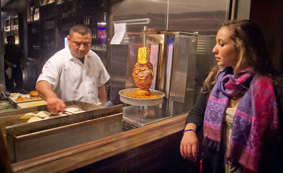 A woman watches Freddy Balam make Tacos at Mosto Bar in San Francisco, Calif., is seen on Friday, November 2nd, 2012.