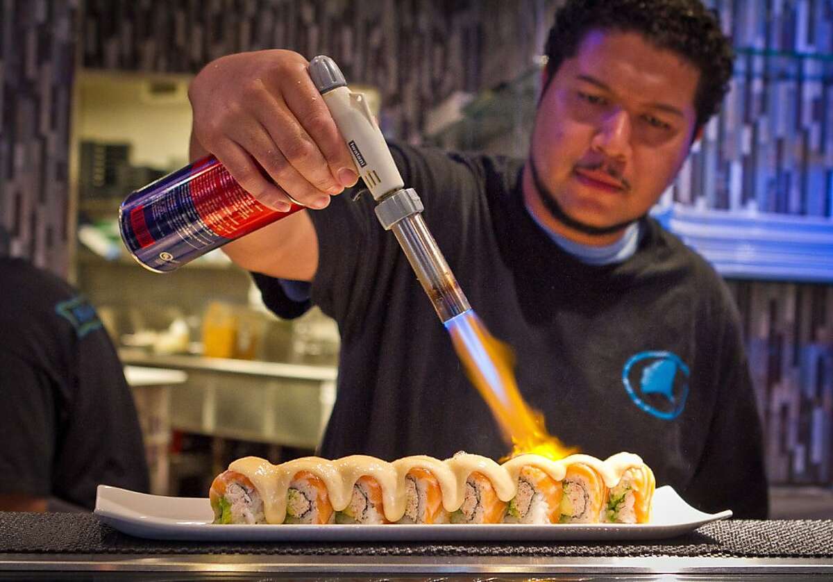 Chef Benjamin Stroughter fires the Salmon Melt sushi roll at Blue Gingko restaurant in Danville, Calif., on Thursday, November 1st, 2012