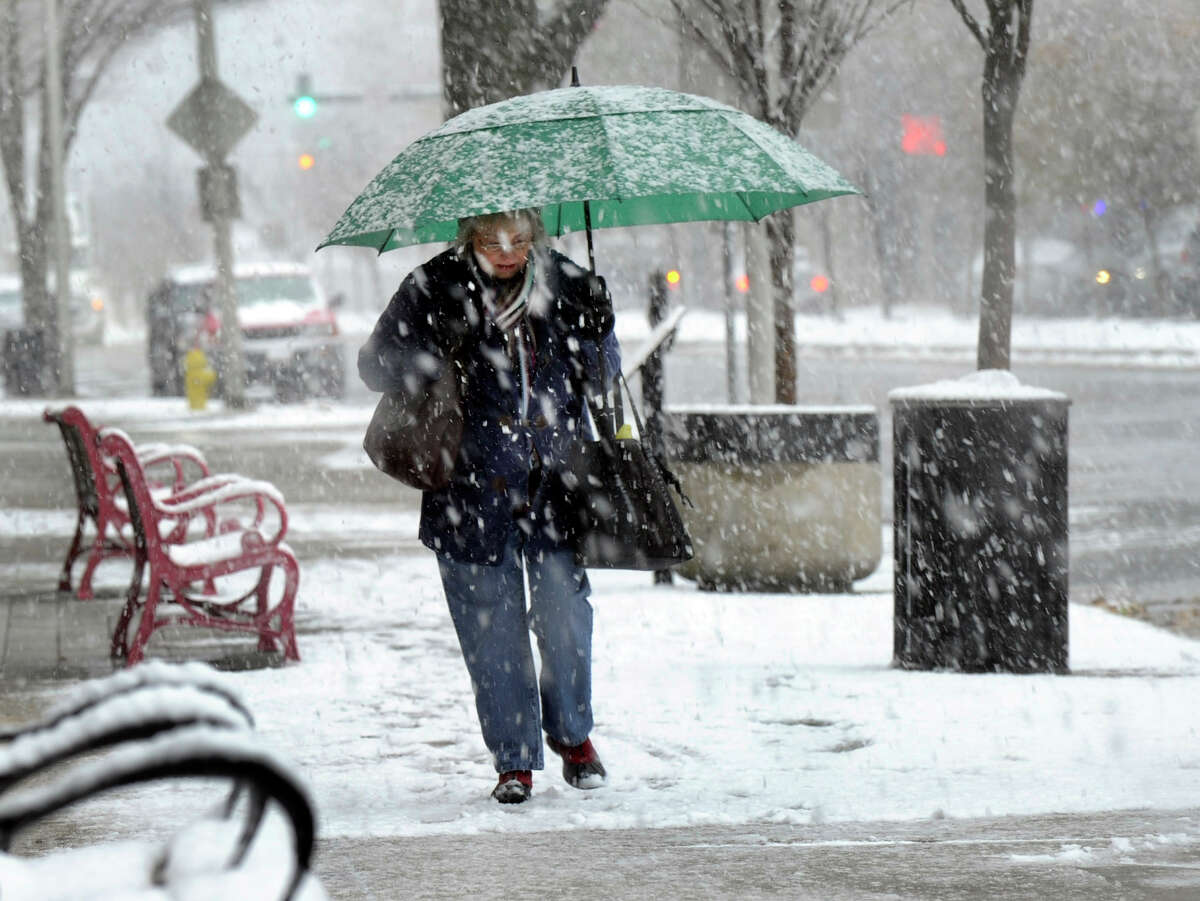 A woman walks in the snow on Main Street in Danbury Wednesday afternoon, Nov. 8, 2012.