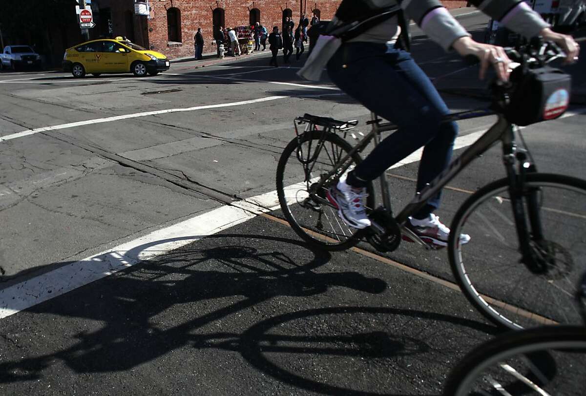The uncovered and covered rail on Jefferson at Hyde streets in San Francisco, Calif., as cyclists pass by on Thursday, November 1, 2012.