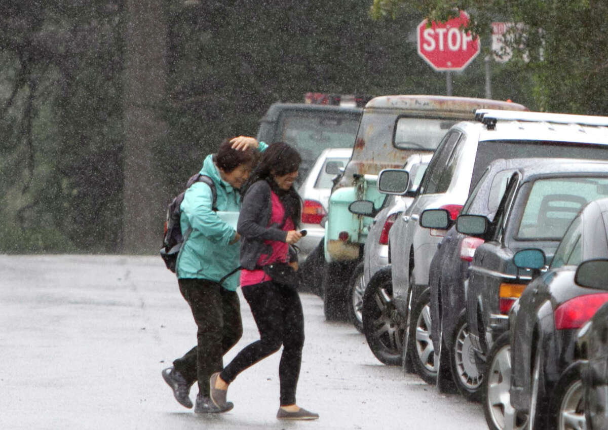 Two pedestrians scramble for cover under a rain shower in the Richmond District of San Francisco on Nov. 8, 2012.