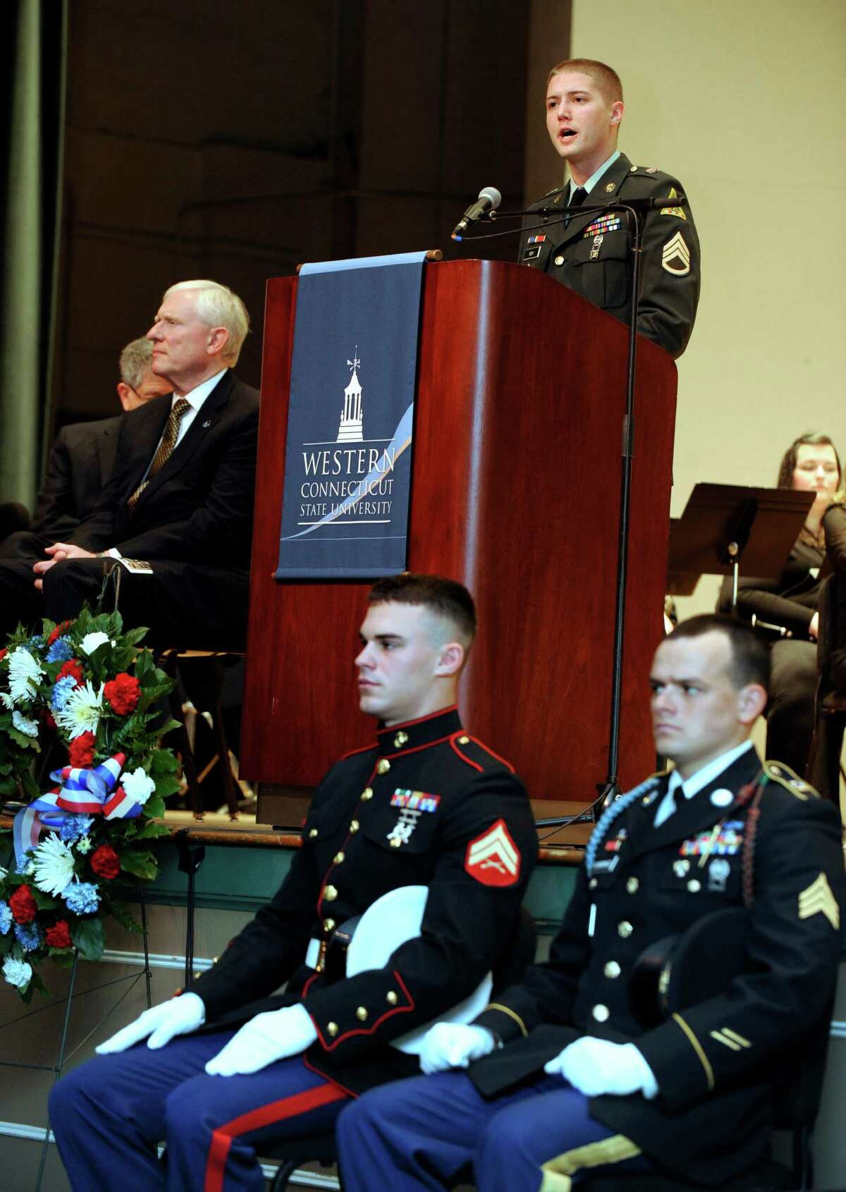 Derek B. Roy,staff sergeant with the Connecticut Army National Guard who is currently working on his MBA at Western Connecticut State University, speaks during the University's Veterans Day program Friday, Nov. 9, 2012. Seated in front are, David Curtis, 23, of Bethel, right, who is in the Marine Corps., and John Cummings, 26, with the Army National Guard.