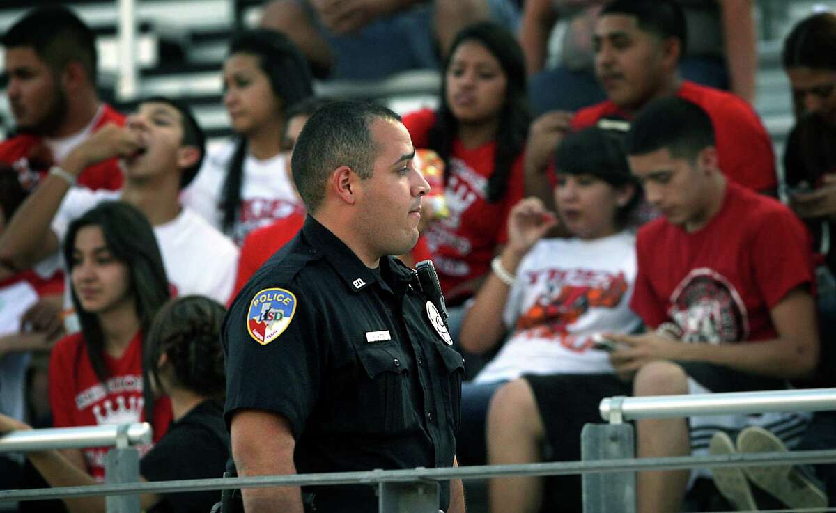 A Laredo Independent School District police officer scans the crowd at a recent Martin High School football game at Shirley Field. Laredo players and coaches deal with issues related to the recent violence across the border. Thursday. Oct. 4, 2012.