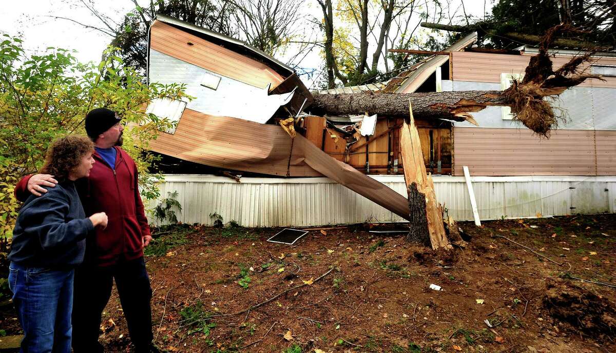 Kathleen Wade and Bill McLean look at her crushed mobile home. McLean pulled Wade from the home after two trees fell on it during Hurricane Sandy in Newtown. Photographed Friday, Nov. 2, 2012.