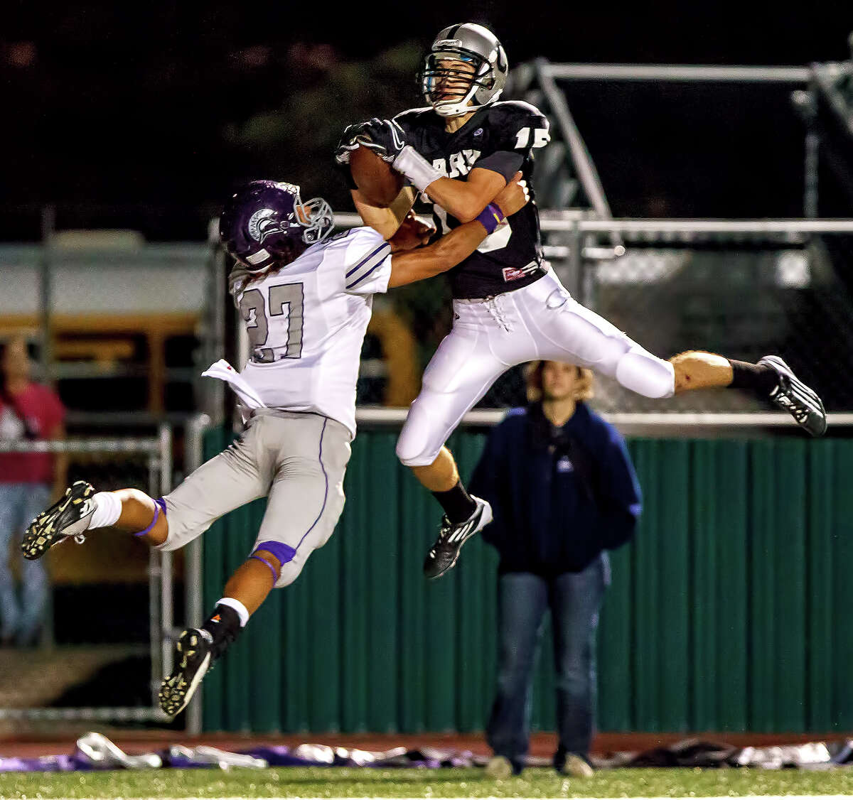 Clark's Presley Miller (right) leaps in the end zone for a 14-yard touchdown reception over Warren's Luis Mercer during the third quarter of their game at Farris Stadium on Nov. 9, 2012. Clark claimed a spot in the playoffs with a 27-26 overtime victory over the Warriors. MARVIN PFEIFFER/ mpfeiffer@express-news.net