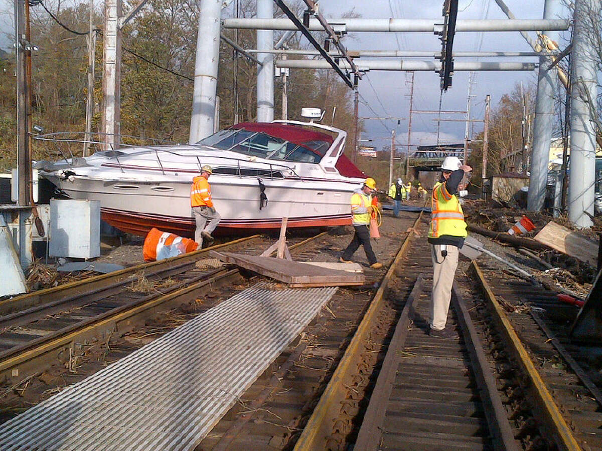 In this photo made available by New Jersey Transit, workers try to clear boats and debris from the New Jersey Transit's Morgan draw bridge Wednesday, Oct. 31, 2012, in South Amboy, N.J. Most mass transit systems were shut down as a result of the storm's damage, leaving hundreds of thousands of commuters braving clogged highways and quarter-mile lines at gas stations. (AP Photo/New Jersey Transit)