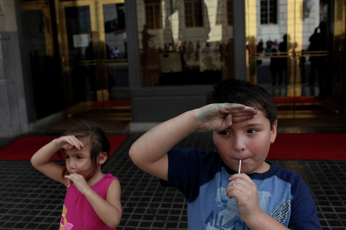 Daniel Vasquez, 7, and his cousin, Raven Borden, 4, salute as soldiers pass during the Veterans Parade in downtown San Antonio on Saturday, Nov. 10, 2012.