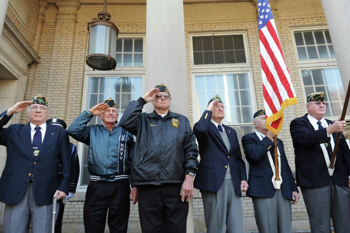 Veterans of the Greenwich American Legion Post 29 salute the flag for Veterans Day event in front of the War Memorial on Greenwich Avenue in Greenwich, Conn., Sunday, Nov. 11, 2012.