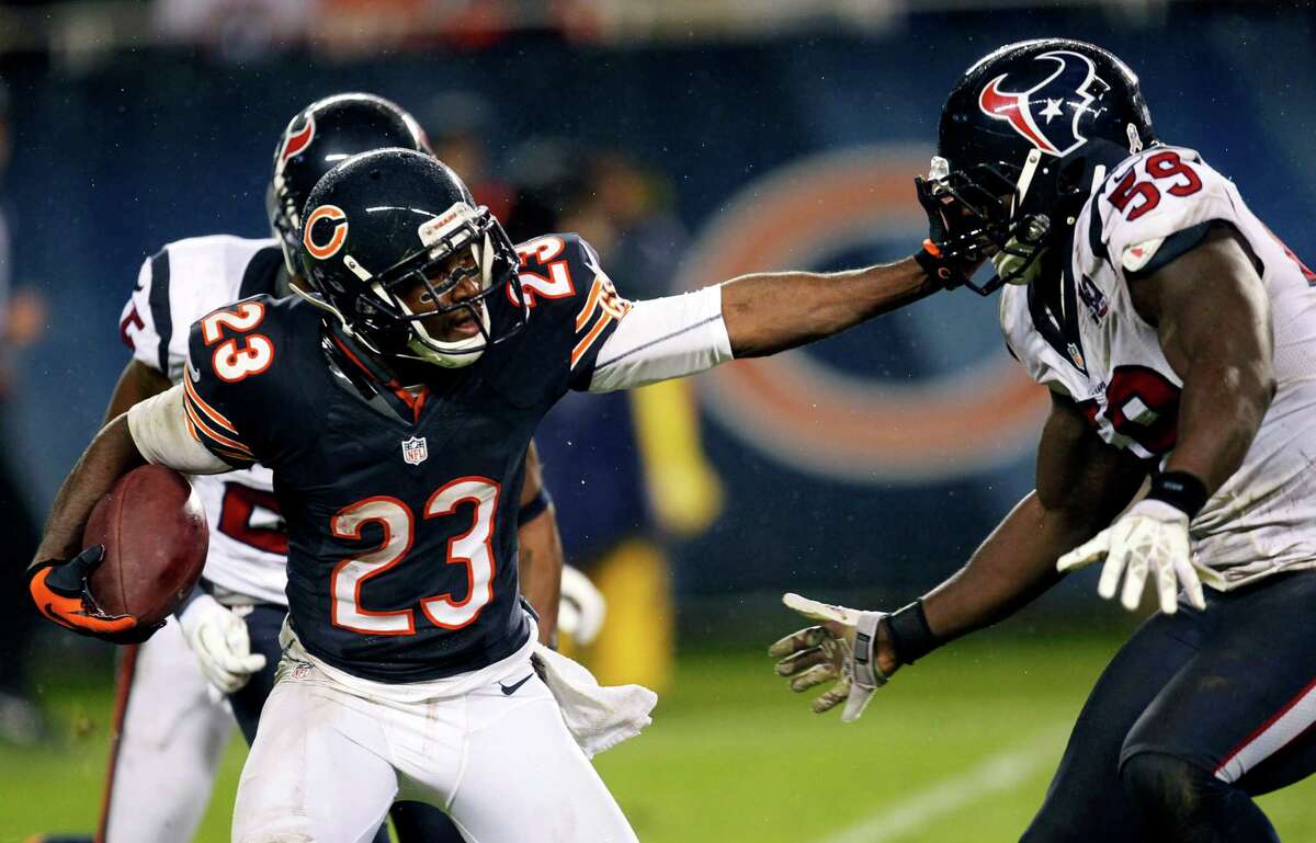 Chicago Bears' Devin Hester (23) stiff-arms Houston Texans' Whitney Mercilus (59) during a punt return during the second half of an NFL football game, Sunday, Nov. 11, 2012, in Chicago. (AP Photo/Charles Rex Arbogast)