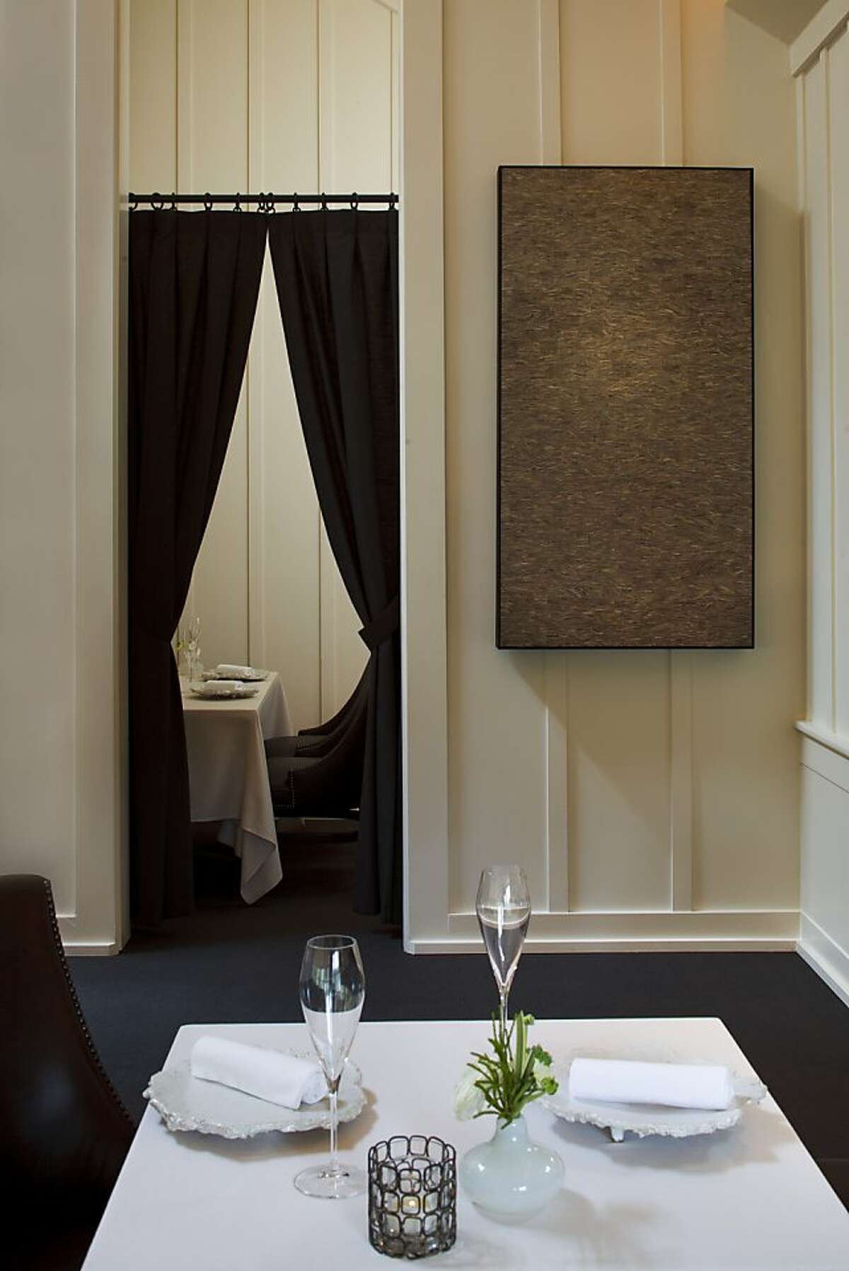 Artwork by Jonah Ward, known as wasp nest, hangs in the main dining room of the Meadowood Resort dining room. The small, private dining area can be seen through the parted curtains.