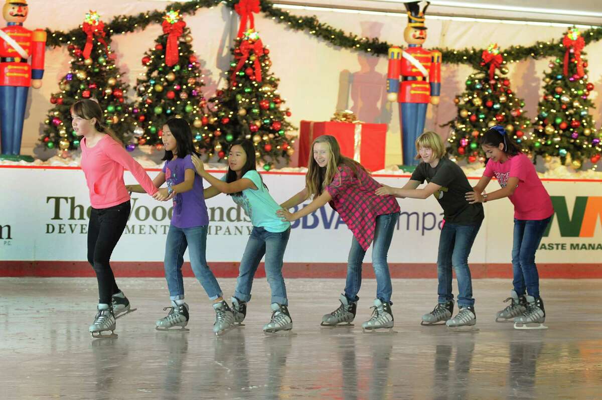 Ice skaters skate past lighted holiday decorations at The Ice Rink at The Woodlands Town Center on the northeast corner of Lake Robbins and Six Pines Drive. The Township is looking for a permanent home for the rink/ The location is temporary, since it is a prime location for commercial development.