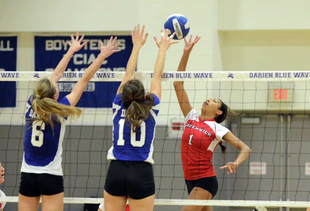 Greenwich's Jenny Cespedes (1) pops the ball over the net as Darien's Kelly Kosnik (6) and Taylor Cockerill (10) defend during the girls volleyball match at Darien High School on Tuesday, Nov. 13, 2012.