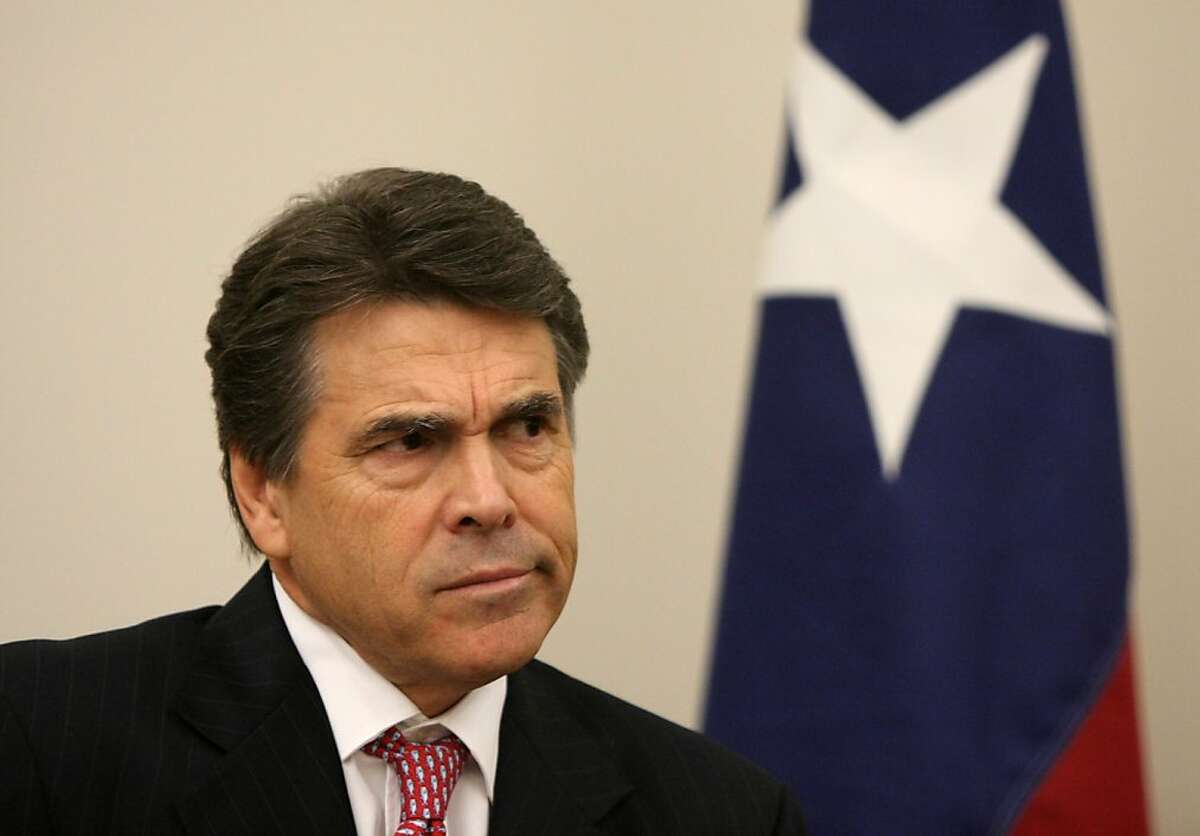 FILE - In this Oct. 13, 2010 file photo, Texas Gov. Rick Perry reacts to questions from news reporters about the Texas Emerging Technology Fund, during a news conference after a town hall meeting with college students at Mountain View College in Dallas. A fourth Texas high-tech startup that received taxpayer money through Gov. Perry's signature economic development fund has filed for bankruptcy, pushing the total losses in the $194 million portfolio beyond what the state says the fund has earned. (AP Photo/The Dallas Morning News, Ben Torres, File) -TV (Mags out, TV out, Internet out, AP Members Only)